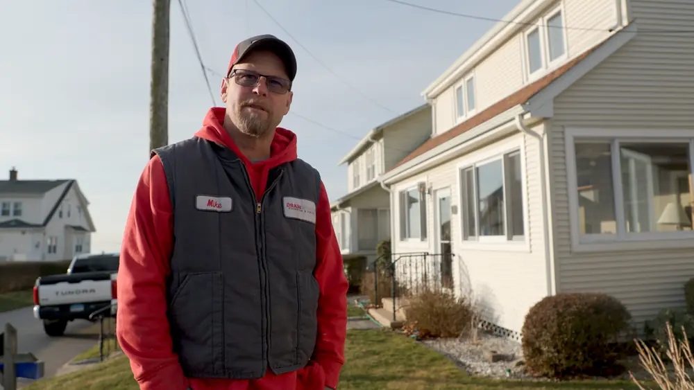 A Drainworks technician in front of a Connecticut home