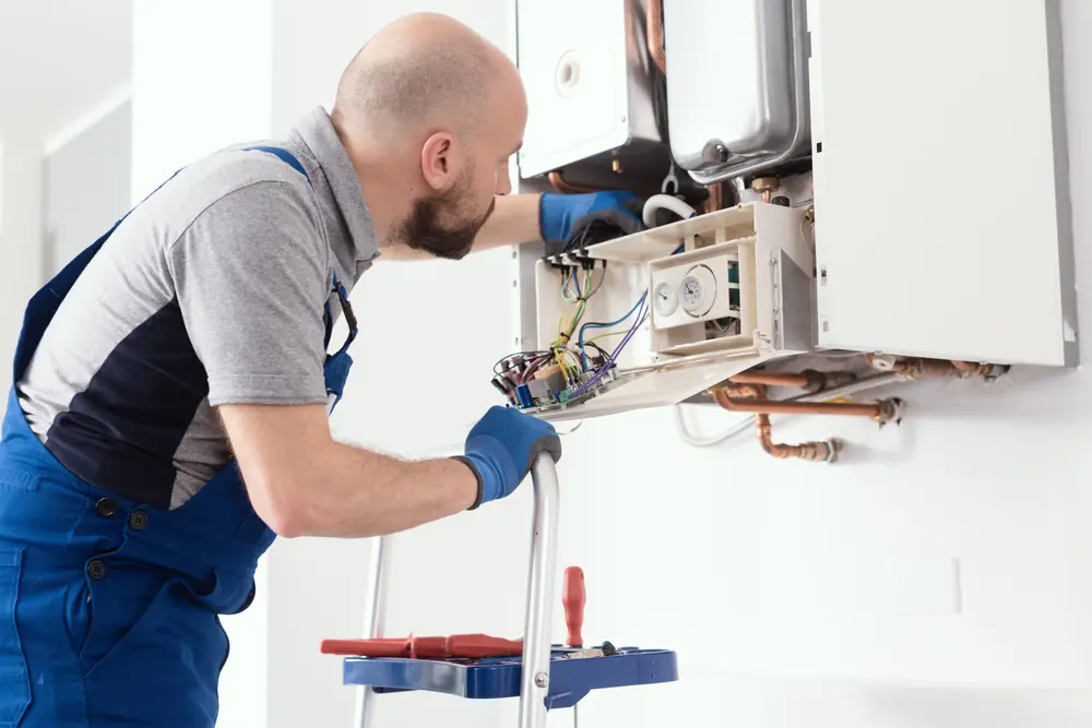 Technician servicing a wall-mounted tankless water heater