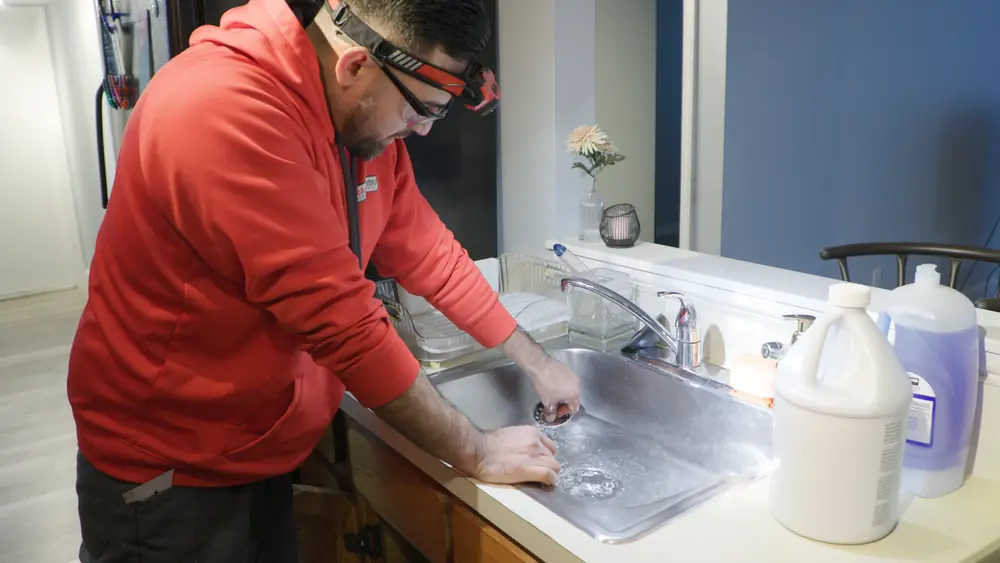 Drainworks technician working at a kitchen sink